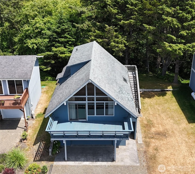 33610 J Pl, Ocean Park, WA 98640 - rear view of house featuring a shingled roof, a wooded view, and a lawn