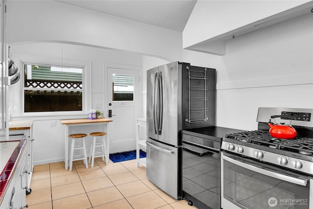 1916 11th Ave W, Seattle, WA 98119 - kitchen featuring stainless steel appliances, tile countertops, and light tile patterned flooring