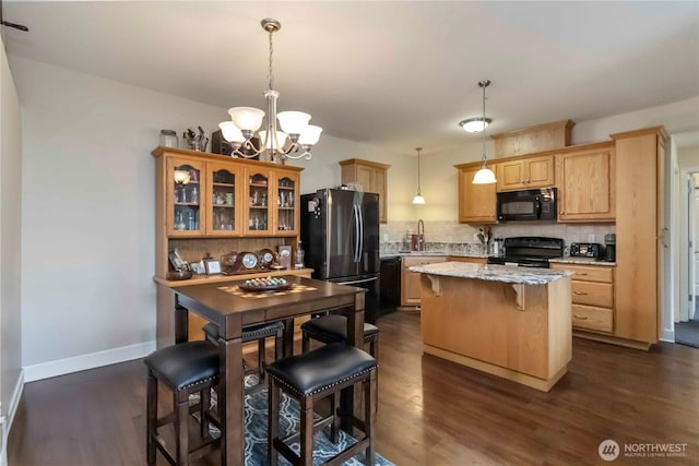 1548 River Rd Unit 301, Longview, WA 98632 - kitchen featuring black appliances, a chandelier, tasteful backsplash, a kitchen island, and a breakfast bar area