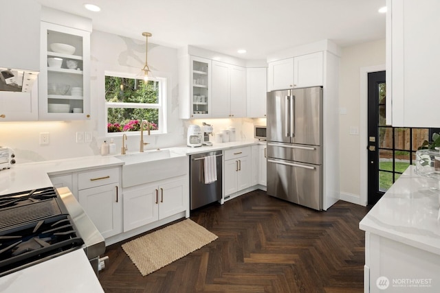 4106 SW Kenyon St, Seattle, WA 98136 - kitchen with stainless steel appliances, white cabinetry, decorative light fixtures, recessed lighting, and glass insert cabinets