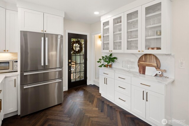 4106 SW Kenyon St, Seattle, WA 98136 - kitchen with freestanding refrigerator, recessed lighting, glass insert cabinets, white cabinets, and light stone counters