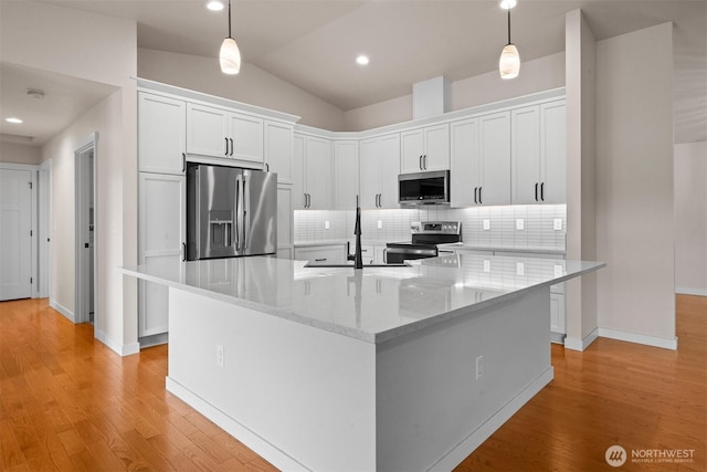 17133 123rd Ct SE, Yelm, WA 98597 - kitchen featuring stainless steel appliances, white cabinetry, decorative backsplash, light wood finished floors, and vaulted ceiling