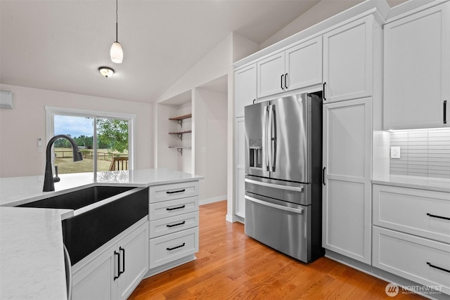 17133 123rd Ct SE, Yelm, WA 98597 - kitchen featuring stainless steel fridge with ice dispenser, lofted ceiling, white cabinets, light wood-style floors, and hanging light fixtures