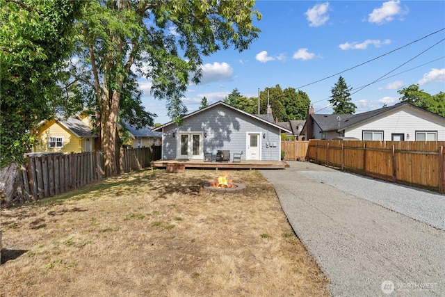 3914 N Gove St, Tacoma, WA 98407 - rear view of property with a fire pit, a deck, asphalt driveway, and a fenced backyard