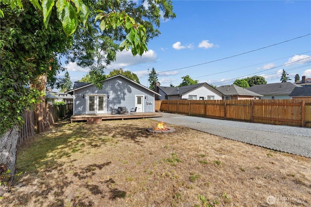 3914 N Gove St, Tacoma, WA 98407 - back of property with an outdoor fire pit, a deck, a fenced backyard, and french doors
