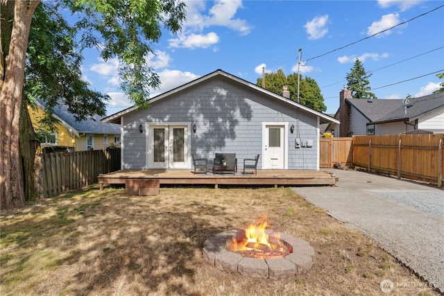 3914 N Gove St, Tacoma, WA 98407 - rear view of house with a deck, french doors, a fire pit, and a fenced backyard
