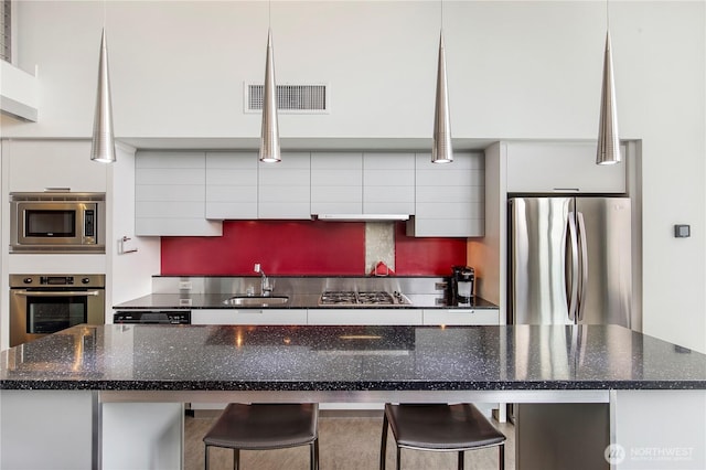 500 Mercer St Unit R325, Seattle, WA 98109 - kitchen featuring stainless steel appliances, white cabinetry, modern cabinets, and a kitchen bar