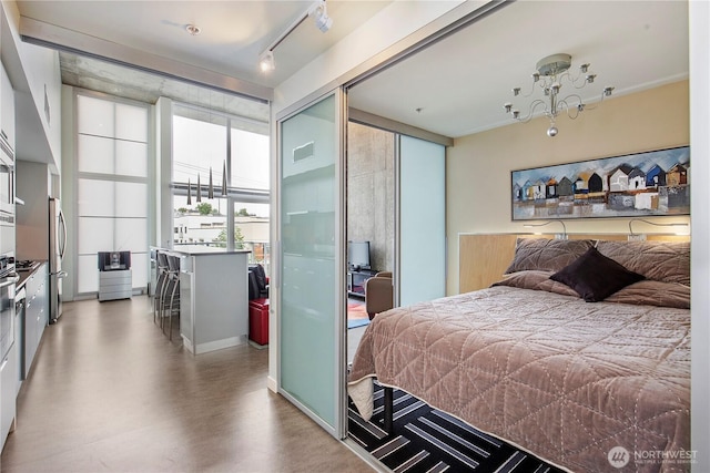 500 Mercer St Unit R325, Seattle, WA 98109 - bedroom with finished concrete floors, a chandelier, a closet, and stainless steel fridge