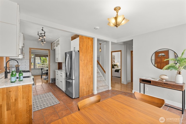 5807 3rd Ave NW, Seattle, WA 98107 - kitchen with freestanding refrigerator, a chandelier, light countertops, and white cabinetry