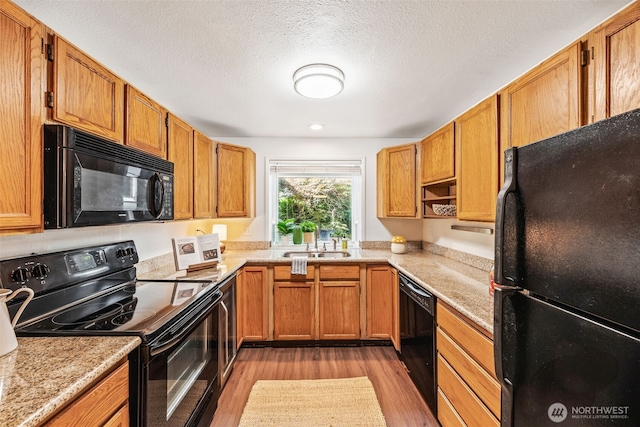 9522 1st Ave NE Unit B6, Seattle, WA 98115 - kitchen with black appliances, light wood-style flooring, light countertops, brown cabinets, and a textured ceiling