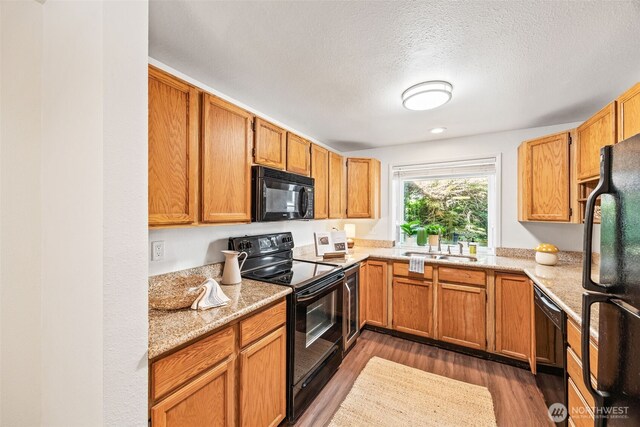 9522 1st Ave NE Unit B6, Seattle, WA 98115 - kitchen featuring black appliances, light wood-type flooring, and a textured ceiling