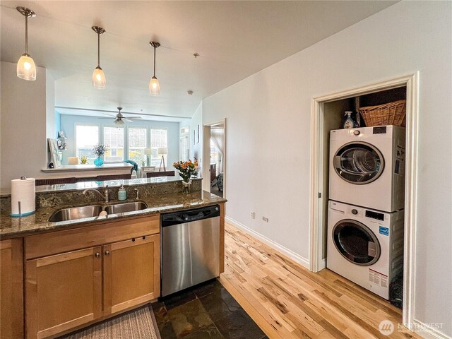 4823 Alderson Rd Unit 207, Blaine, WA 98230 - kitchen featuring stainless steel dishwasher, stacked washer / drying machine, dark stone counters, decorative light fixtures, and ceiling fan