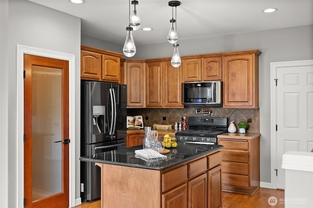 32216 Bruckners Way, Black Diamond, WA 98010 - kitchen featuring stainless steel appliances, tasteful backsplash, light wood finished floors, dark stone countertops, and pendant lighting