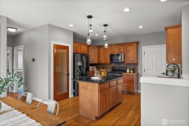 32216 Bruckners Way, Black Diamond, WA 98010 - kitchen featuring black appliances, light wood finished floors, backsplash, a kitchen island, and pendant lighting