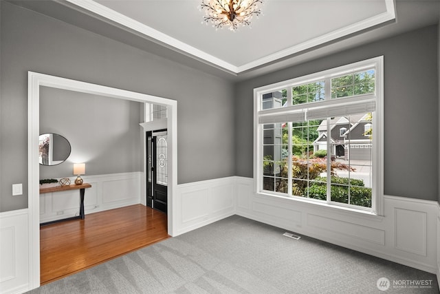 32216 Bruckners Way, Black Diamond, WA 98010 - carpeted empty room with a wainscoted wall, a chandelier, a raised ceiling, and a decorative wall