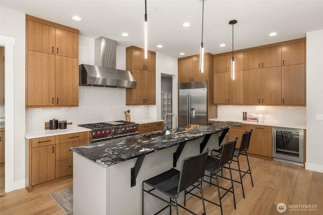 21025 SE 80th St, Issaquah, WA 98027 - kitchen featuring high quality appliances, wall chimney exhaust hood, wine cooler, light wood-style floors, and tasteful backsplash
