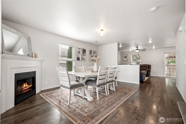 1105 Nunnally Ave NW, Orting, WA 98360 - dining space featuring a glass covered fireplace, dark wood finished floors, and a ceiling fan