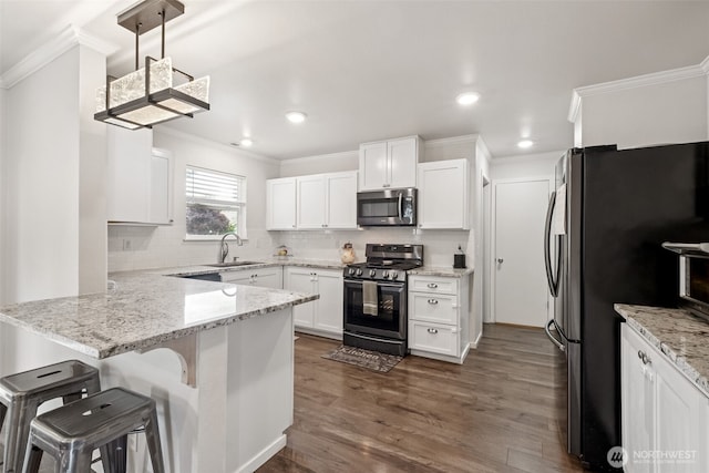 1105 Nunnally Ave NW, Orting, WA 98360 - kitchen with stainless steel appliances, ornamental molding, a peninsula, white cabinets, and backsplash