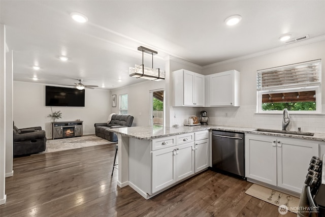 1105 Nunnally Ave NW, Orting, WA 98360 - kitchen featuring dishwasher, white cabinetry, a peninsula, a warm lit fireplace, and a ceiling fan