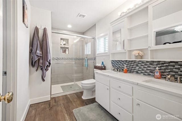 1105 Nunnally Ave NW, Orting, WA 98360 - bathroom featuring double vanity, a shower stall, wood finished floors, tasteful backsplash, and recessed lighting