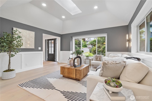 3696 169th Ave NE, Bellevue, WA 98008 - living room featuring lofted ceiling, a skylight, a decorative wall, wood finished floors, and wainscoting