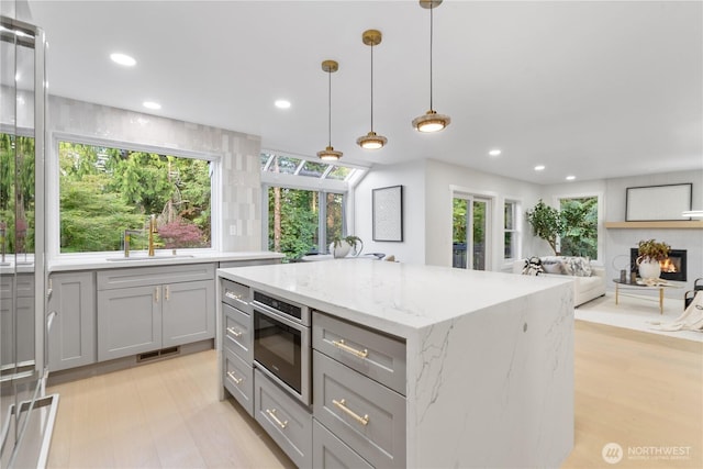 3696 169th Ave NE, Bellevue, WA 98008 - kitchen featuring gray cabinetry, light stone countertops, decorative light fixtures, a kitchen island, and recessed lighting