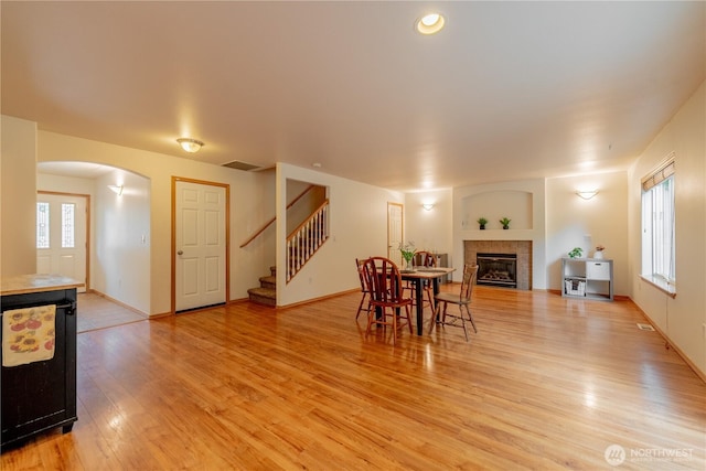 13858 Dogwood Ct, Sultan, WA 98294 - dining area with arched walkways, light wood finished floors, stairs, and healthy amount of natural light