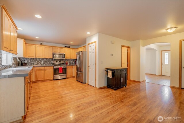 13858 Dogwood Ct, Sultan, WA 98294 - kitchen with stainless steel appliances, arched walkways, light brown cabinetry, light wood finished floors, and recessed lighting