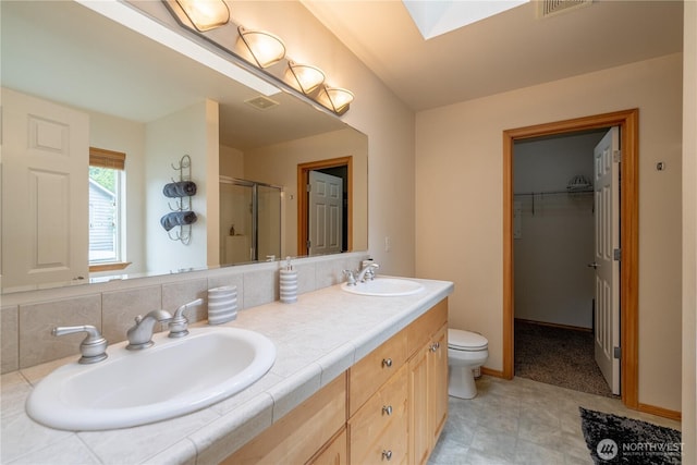 13858 Dogwood Ct, Sultan, WA 98294 - full bathroom with a stall shower, double vanity, a skylight, and a walk in closet