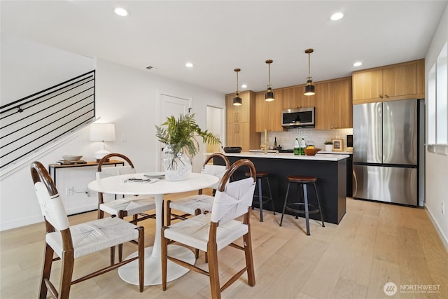 8227 Latona Ave NE, Seattle, WA 98115 - dining room with recessed lighting, light wood-style flooring, and stairway
