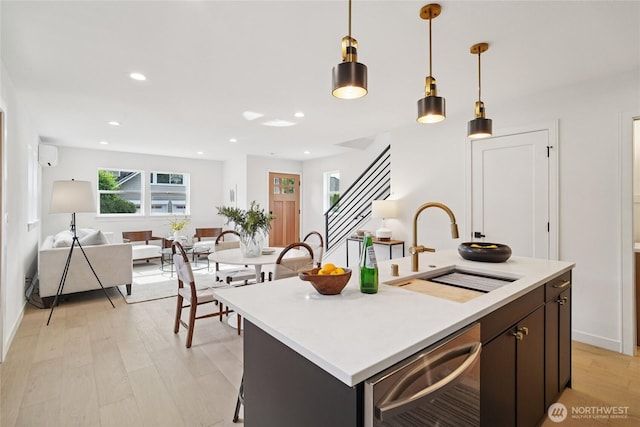 8227 Latona Ave NE, Seattle, WA 98115 - kitchen with stainless steel dishwasher, hanging light fixtures, light countertops, light wood-type flooring, and recessed lighting
