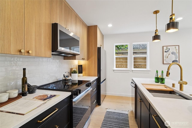 8227 Latona Ave NE, Seattle, WA 98115 - kitchen featuring appliances with stainless steel finishes, light countertops, decorative backsplash, dark cabinets, and recessed lighting