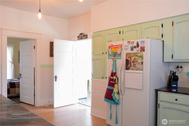 202 E 3rd Ave, Ritzville, WA 99169 - kitchen with freestanding refrigerator, green cabinets, decorative light fixtures, and light wood finished floors