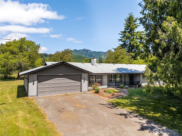 262 Falls Rd, Randle, WA 98377 - single story home featuring covered porch, asphalt driveway, a front yard, a garage, and a chimney