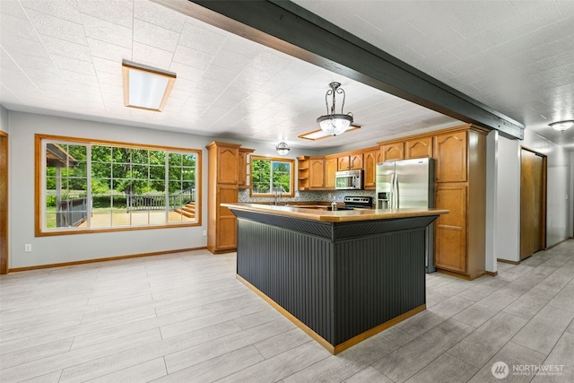 262 Falls Rd, Randle, WA 98377 - kitchen with stainless steel appliances, light wood-style floors, an island with sink, and decorative light fixtures