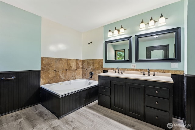 262 Falls Rd, Randle, WA 98377 - full bath with double vanity, a bath, a wainscoted wall, and wood finished floors
