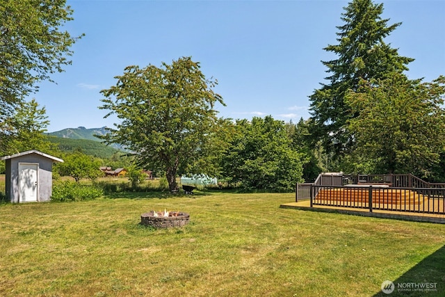 262 Falls Rd, Randle, WA 98377 - view of grassy yard featuring a fire pit, a storage shed, and a deck with mountain view