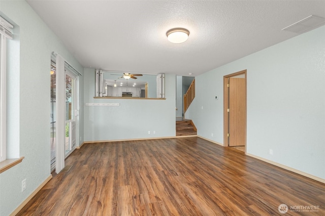 5411 Komachin Loop SE, Lacey, WA 98513 - unfurnished living room with wood finished floors, stairway, ceiling fan, and a textured ceiling