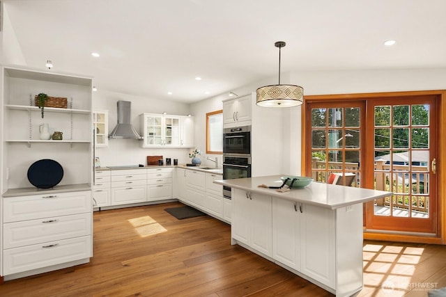 12238 9th Ave NW, Seattle, WA 98177 - kitchen featuring wall chimney exhaust hood, light wood-type flooring, white cabinets, double oven, and recessed lighting