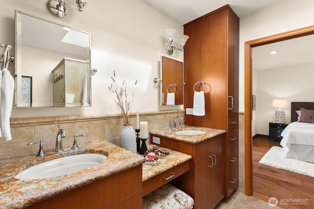 12238 9th Ave NW, Seattle, WA 98177 - ensuite bathroom featuring two vanities, wood finished floors, tile walls, and a wainscoted wall