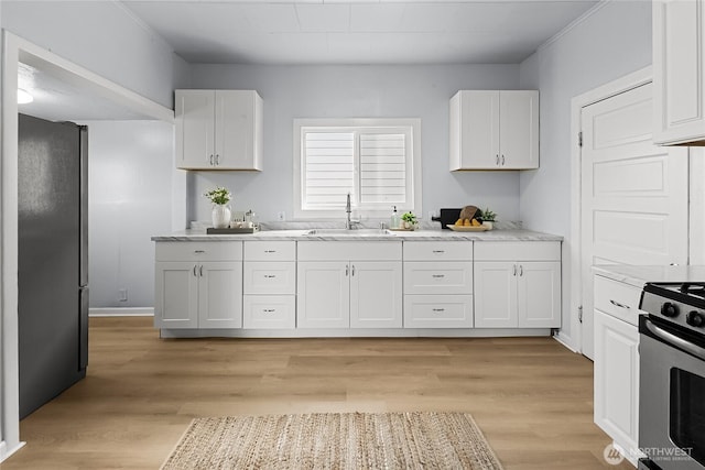 1103 E 59th St, Tacoma, WA 98404 - kitchen featuring stainless steel appliances, white cabinets, and light wood-style floors
