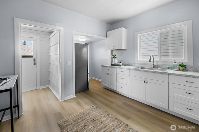 1103 E 59th St, Tacoma, WA 98404 - kitchen with light countertops, light wood-style flooring, and white cabinetry
