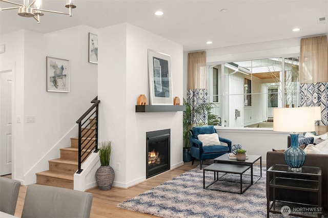 13446 HS4 NE 112th Pl, Redmond, WA 98052 - living room featuring wood finished floors, stairway, a glass covered fireplace, recessed lighting, and a chandelier
