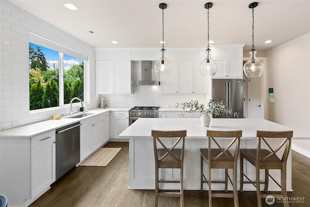 10702 39th Ave NE, Seattle, WA 98125 - kitchen featuring premium appliances, wall chimney exhaust hood, a kitchen island, tasteful backsplash, and dark wood-style flooring
