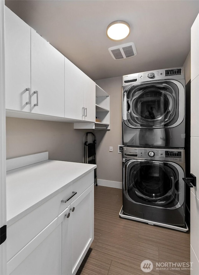 10702 39th Ave NE, Seattle, WA 98125 - washroom featuring stacked washer and clothes dryer and cabinet space
