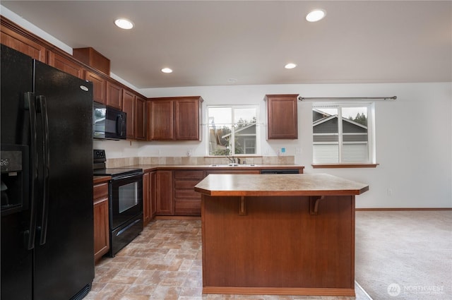 20614 6th Avenue Ct E, Spanaway, WA 98387 - kitchen with black appliances, healthy amount of natural light, a center island, a breakfast bar, and recessed lighting