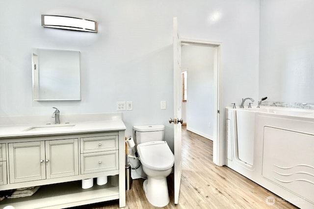 132 Milky Way, Sequim, WA 98382 - bathroom featuring washing machine and dryer, wood finished floors, vanity, and a garden tub