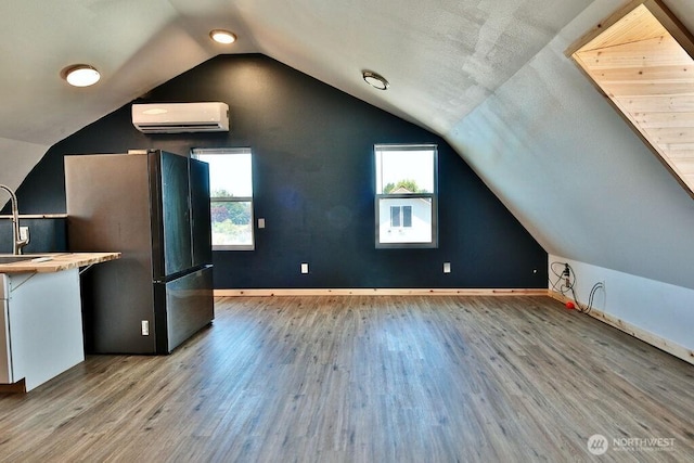 132 Milky Way, Sequim, WA 98382 - additional living space with a wall mounted air conditioner, wood finished floors, and vaulted ceiling