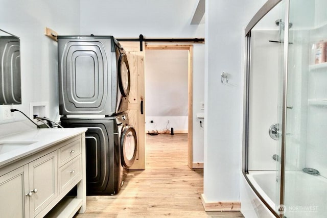 132 Milky Way, Sequim, WA 98382 - laundry room with stacked washer / drying machine, light wood-type flooring, and a barn door