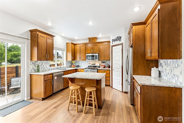 815 6th Ave SW, Olympia, WA 98512 - kitchen with stainless steel appliances, light wood-type flooring, a kitchen breakfast bar, backsplash, and recessed lighting